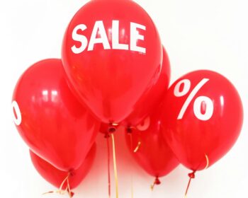 Bright red balloons with 'SALE' and '%' symbols, perfect for marketing promotions.