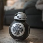 A star wars droid toy sitting on the floor
