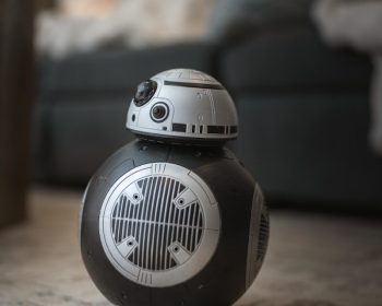 A star wars droid toy sitting on the floor