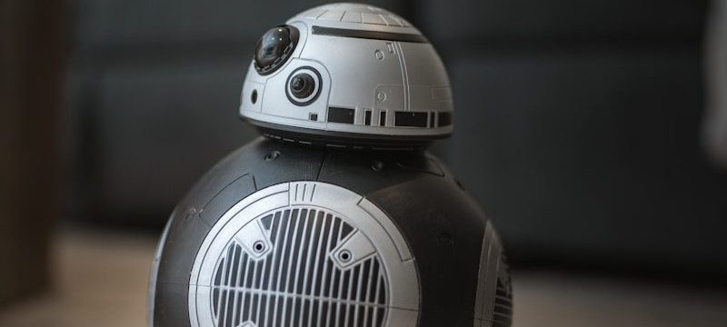 A star wars droid toy sitting on the floor
